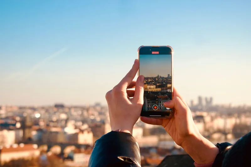 旅先の街並みをスマートフォンで撮影する旅行者の手元