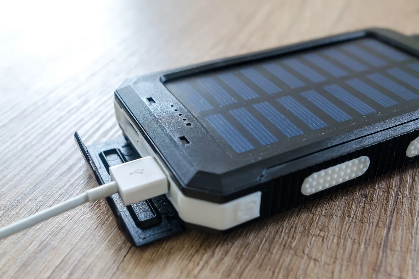 木の机に置いたモバイルバッテリーとUSBケーブル