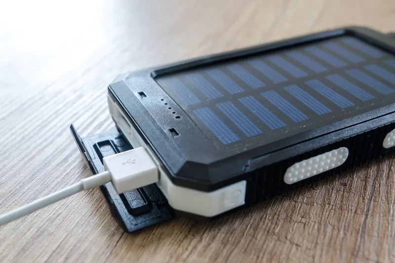 木の机に置いたモバイルバッテリーとUSBケーブル