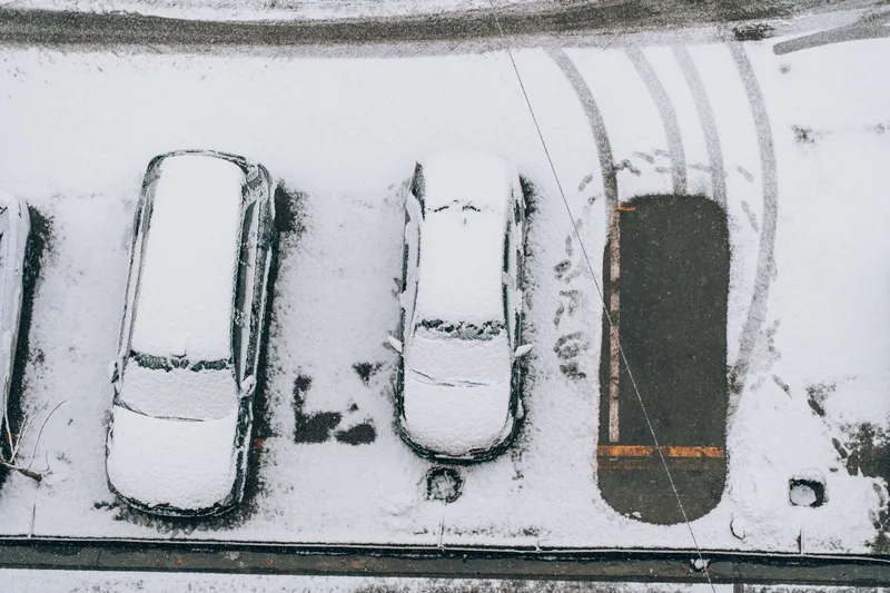 雪が積もった駐車場に停まっている車