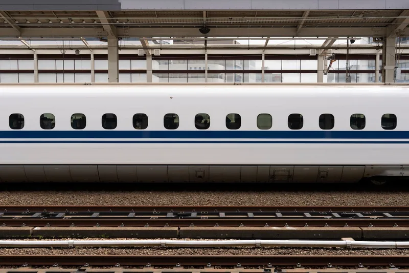 駅のホームに停車する新幹線車両の側面