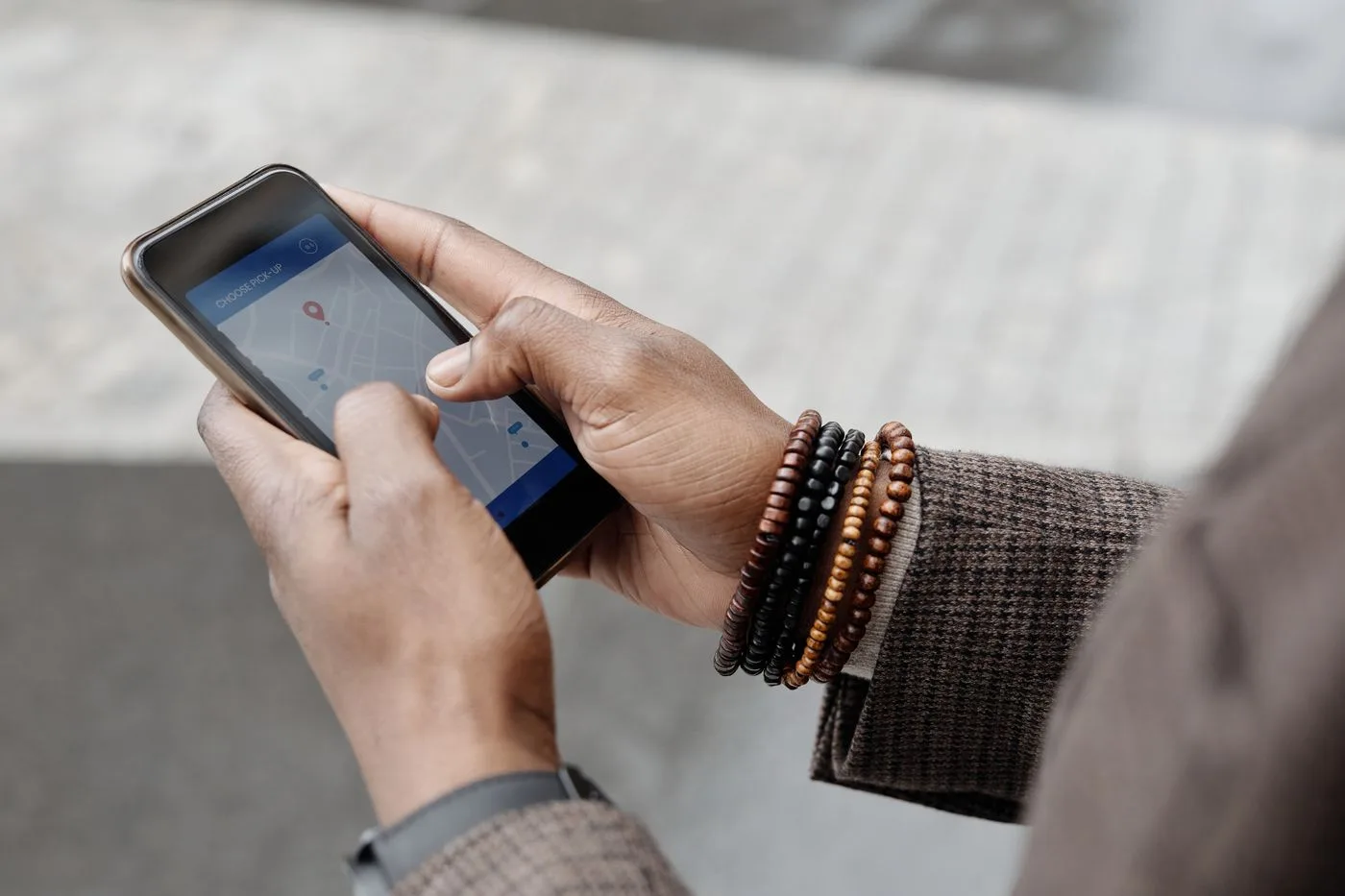 地図アプリを開いたスマートフォンを手に持つ旅行者の手元