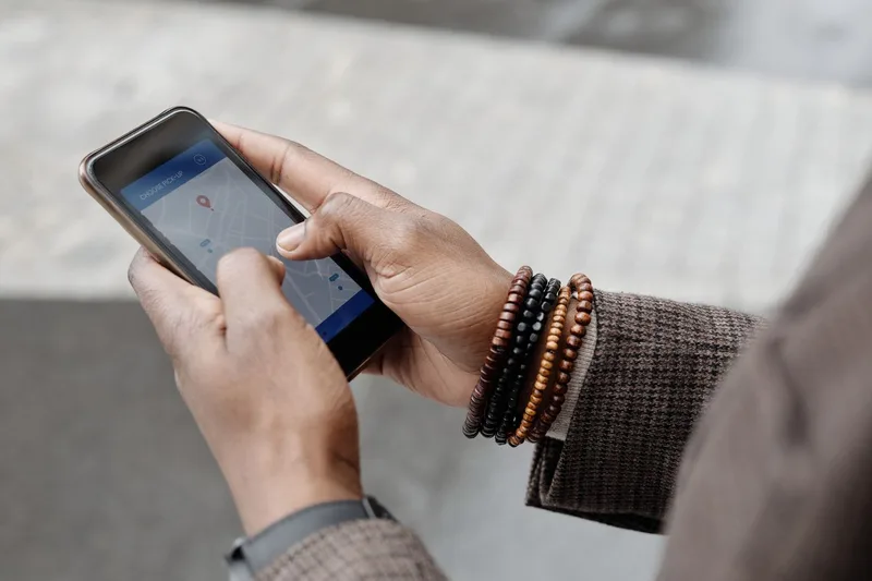 地図アプリを開いたスマートフォンを手に持つ旅行者の手元