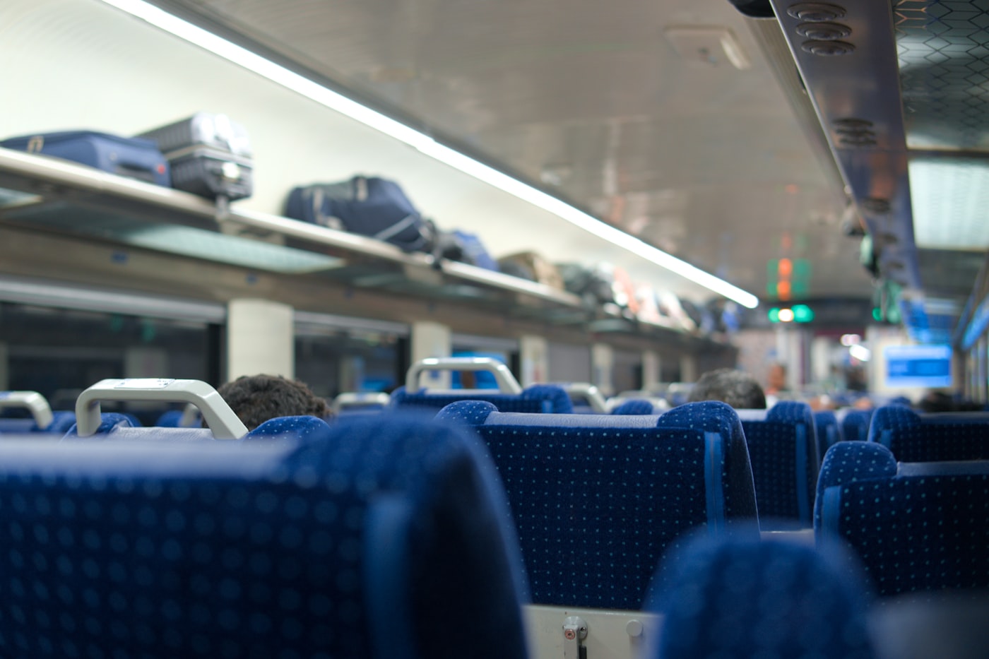 列車の荷物棚に載せられたスーツケースとボストンバッグ